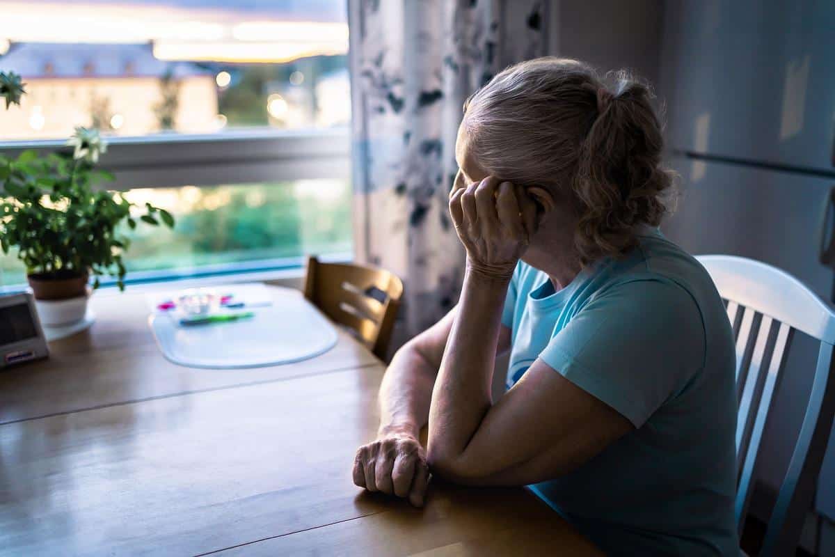 Older woman alone looking out window